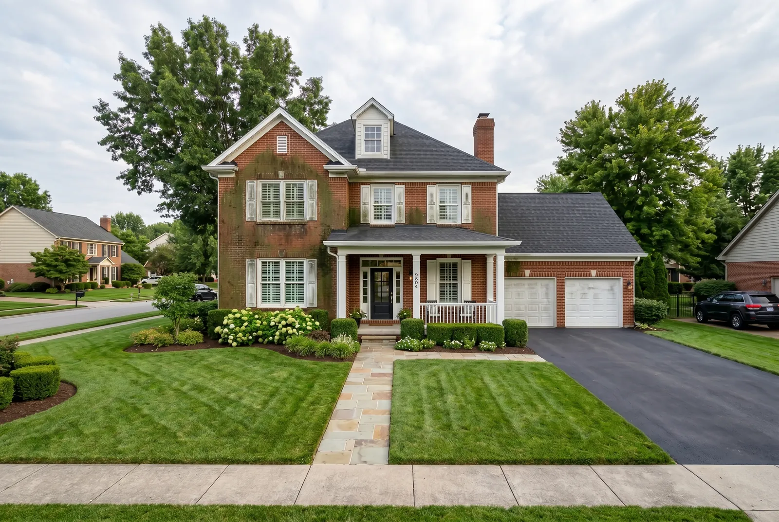 Brick home before soft washing in Prospect, KY, algae and grime on the brick and white trim