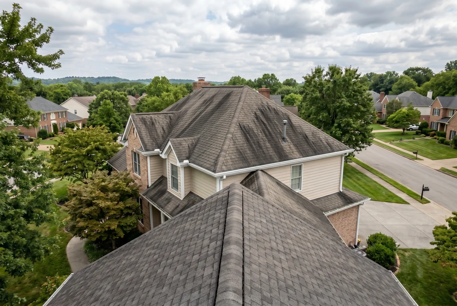 Asphalt shingle roof before soft washing in Norton Commons, KY, heavy black algae streaks